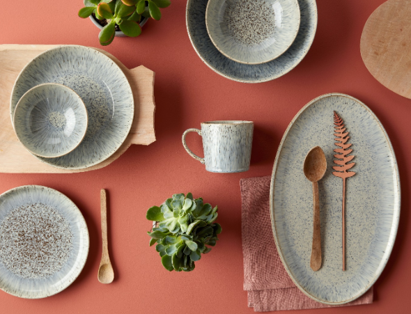 A birds eye photo of some Denby crockery arranged on a tablecloth.