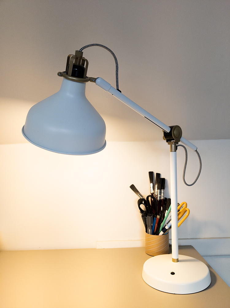 A photo of a task lamp where the shade directs the light to a narrow area