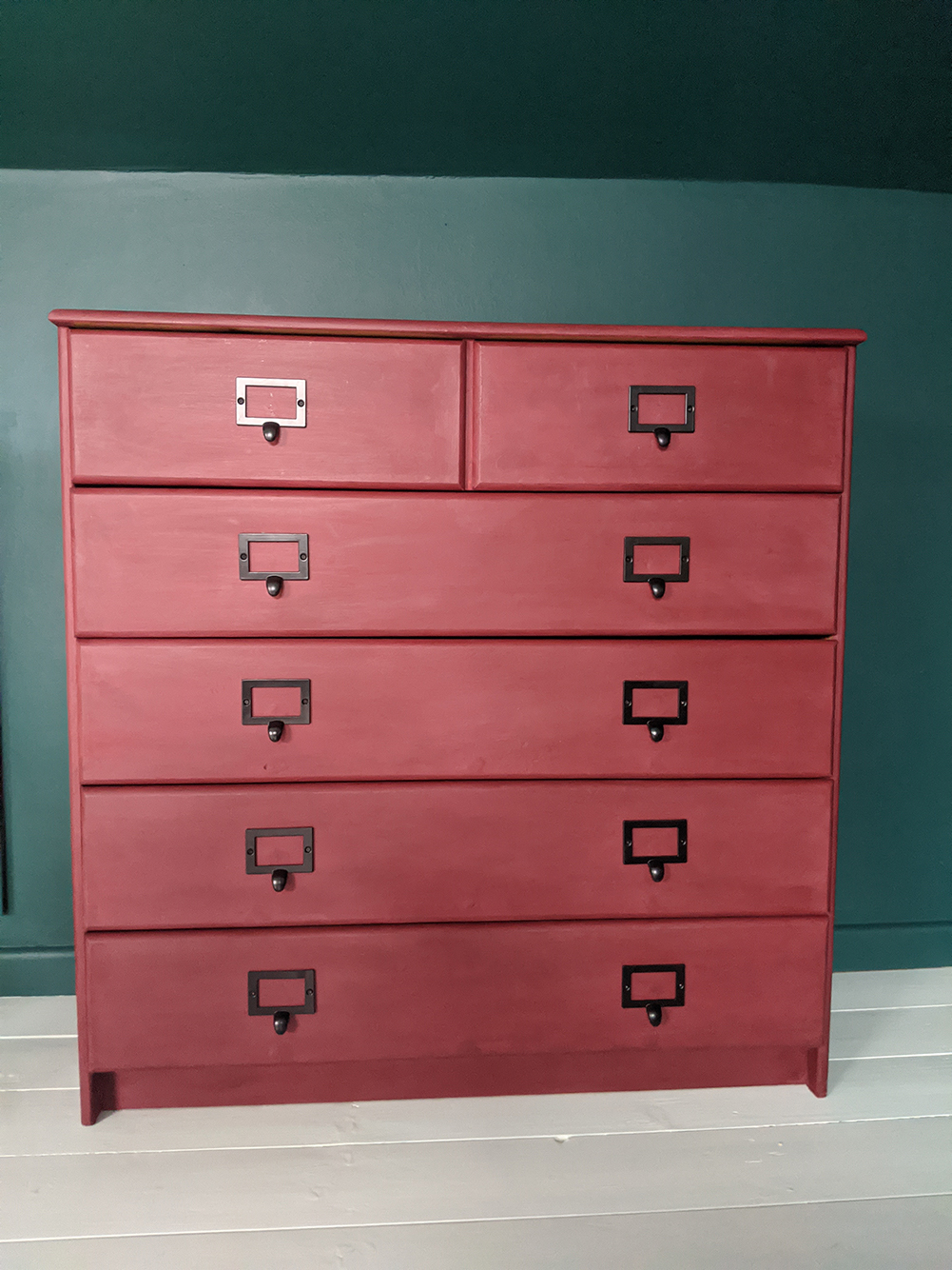A photo of the finished chest of drawers, with new handles.