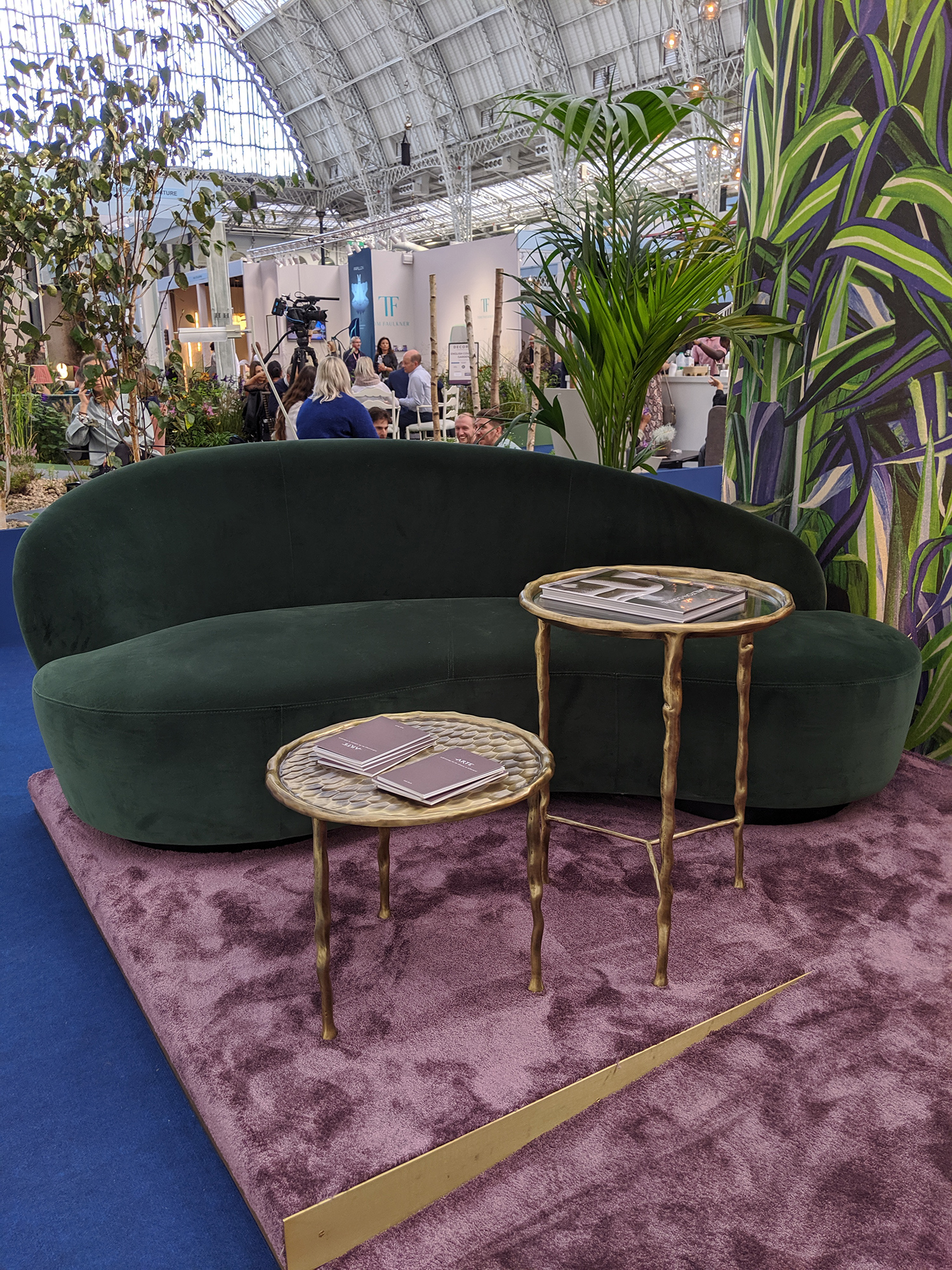 A velvet, green and curved sofa.