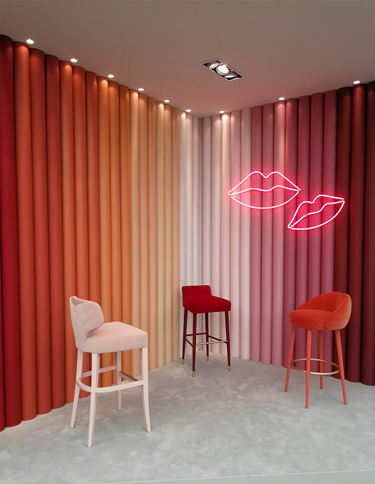 a photo of a stand at a trade fair with a row of coloured poles ranging from reds to pinks