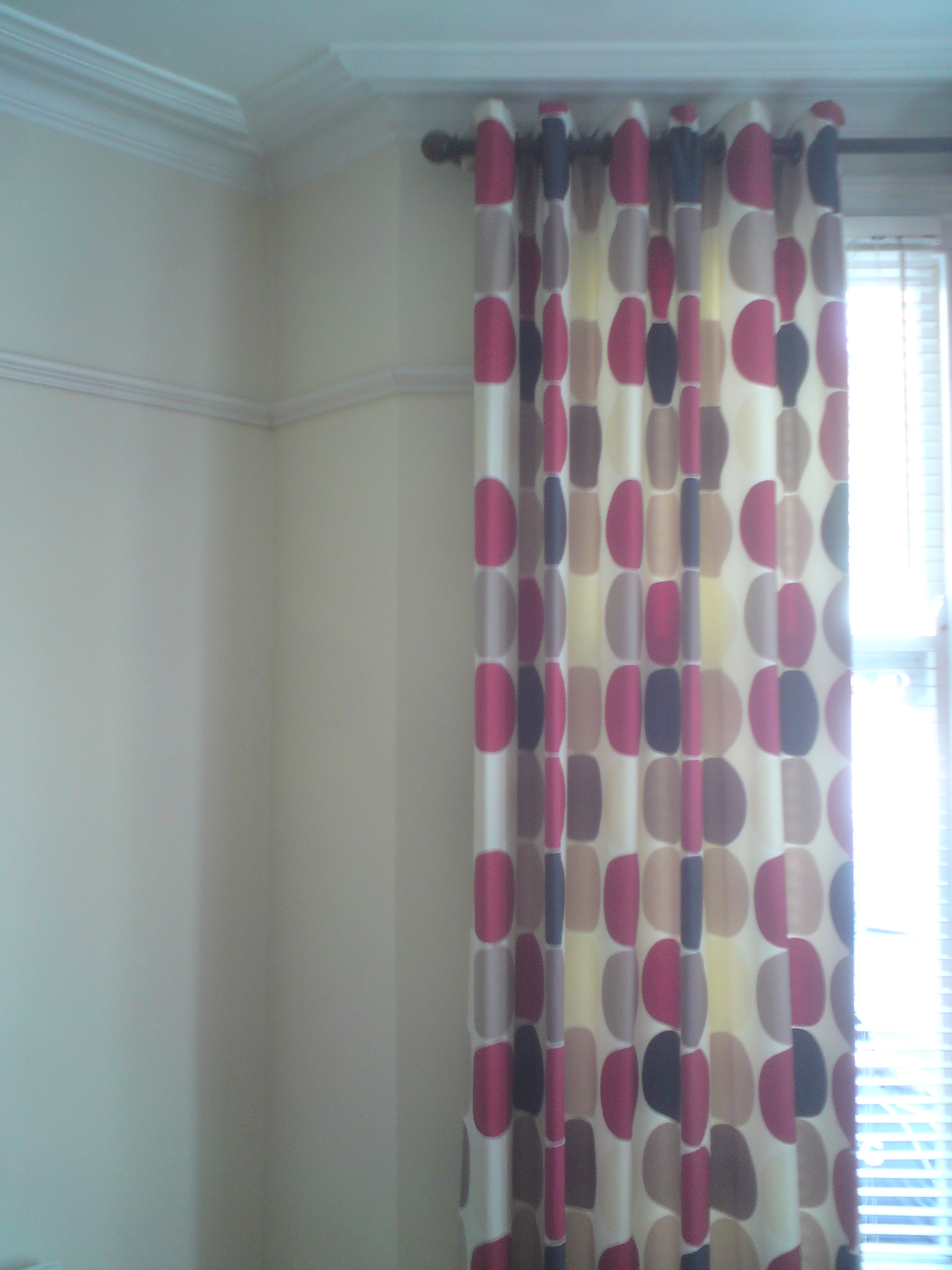 a photo of my temporary curtains in the living room with cream walls
