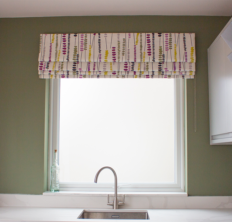 A photo of the sage green wall and Roman blind from this project.