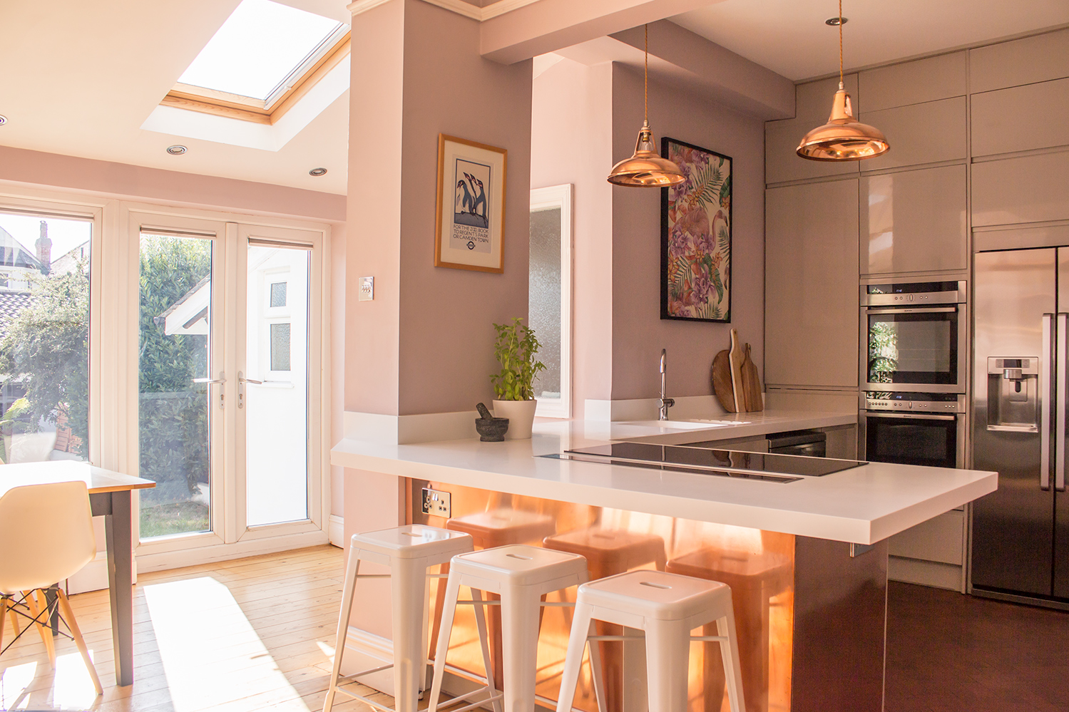 A view of a kitchen I designed, with copper lighting over the breakfast bar and copper around the units.
