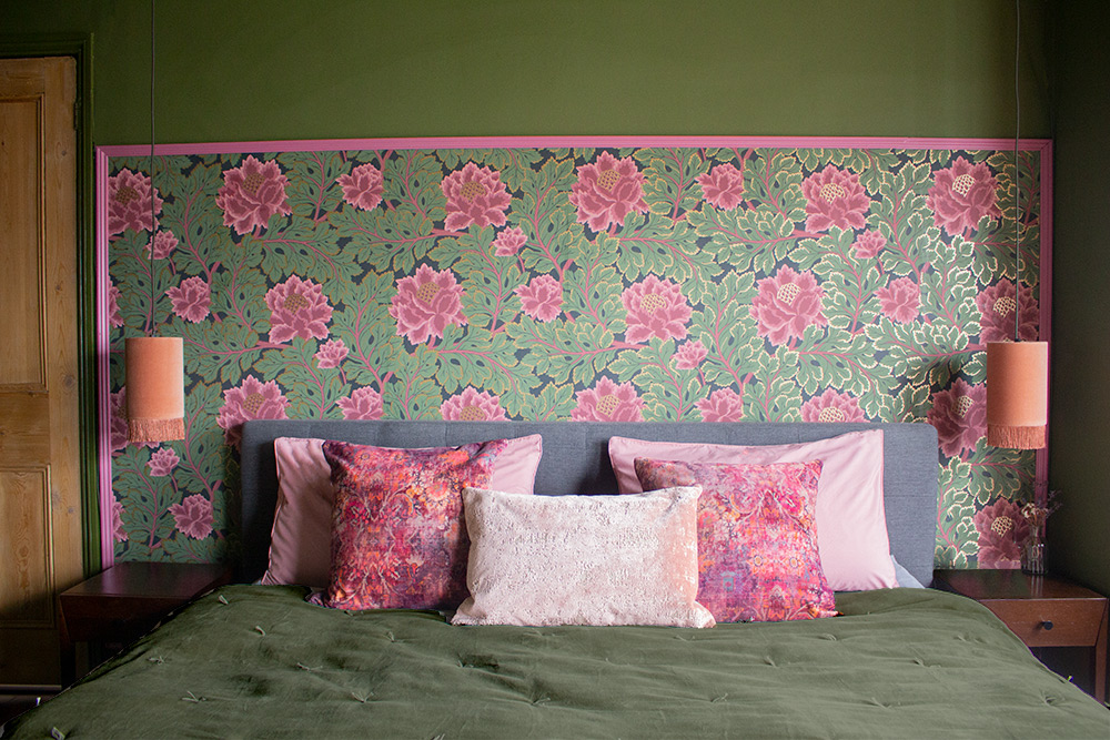 The same bedroom when the project was finished - with dark green walls and statement wallpaper.