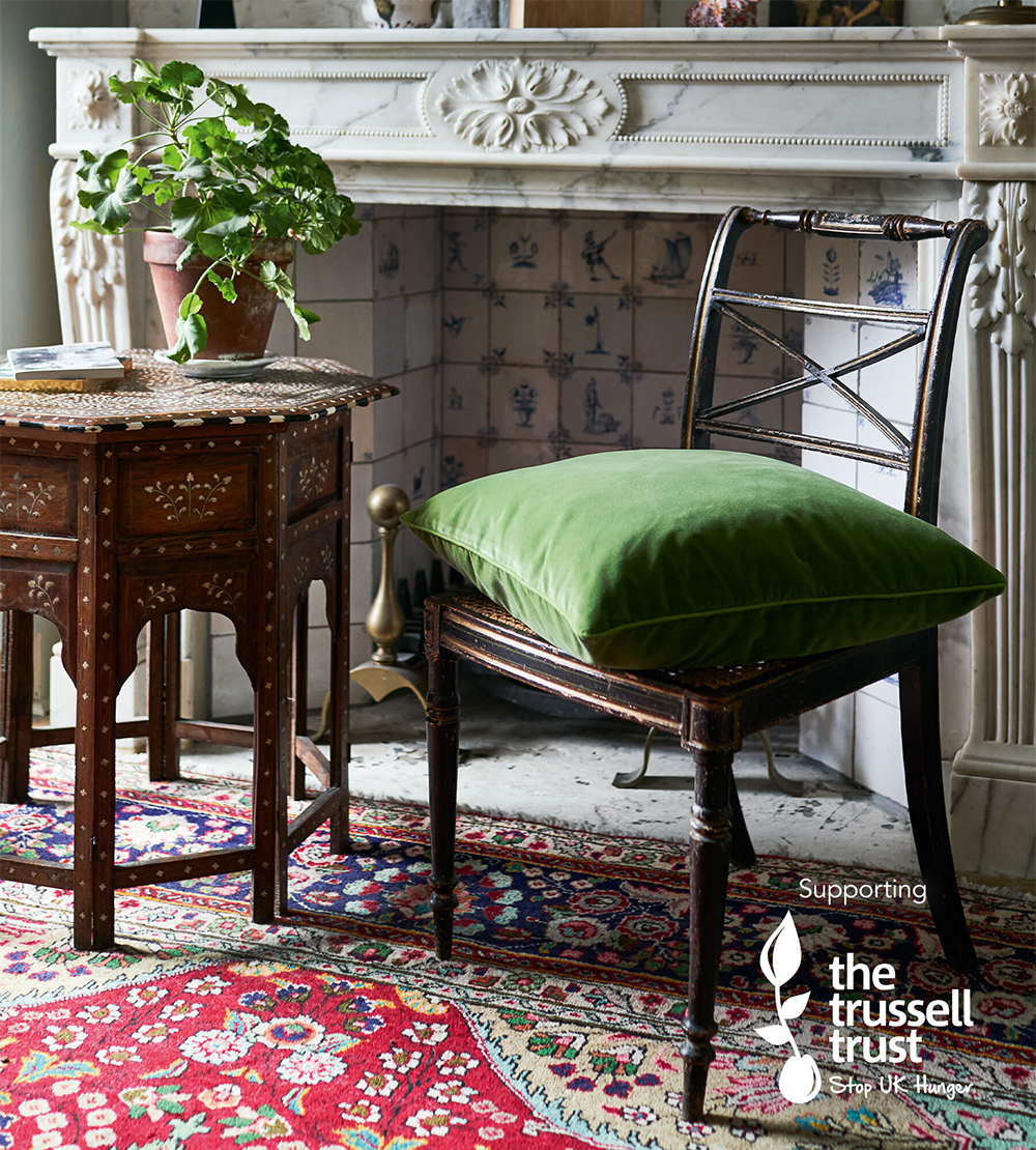 A photo of the green velvet cushion on a chair.
