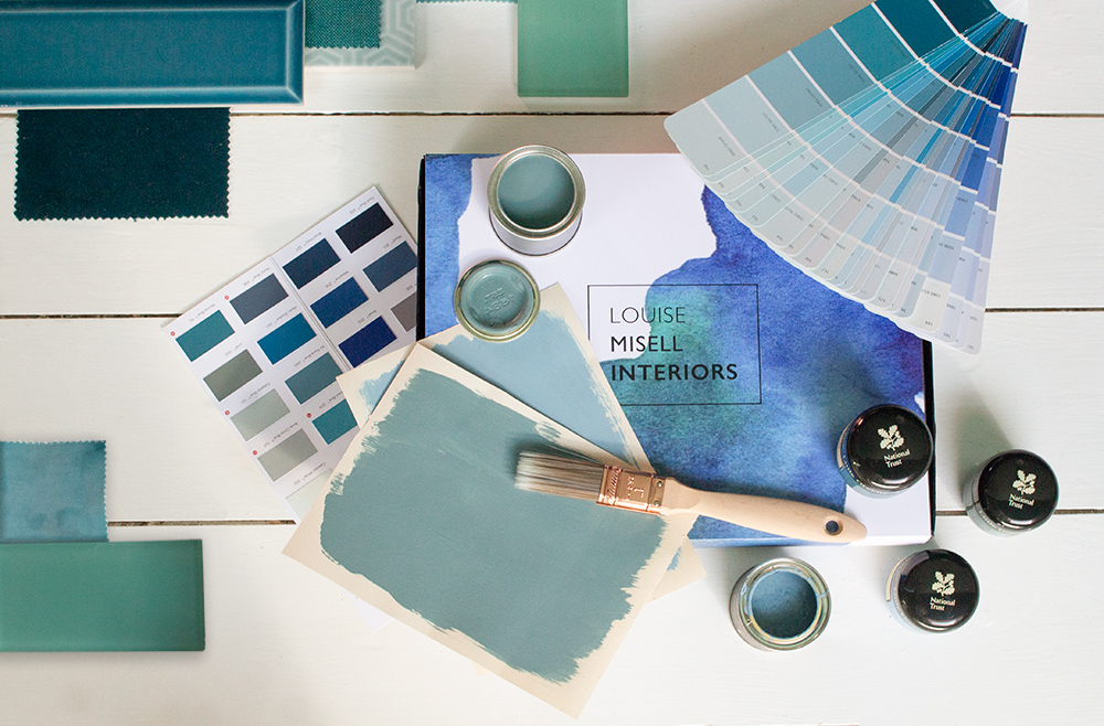 A photo of the Designer in a Box with paint and fabric samples around it.