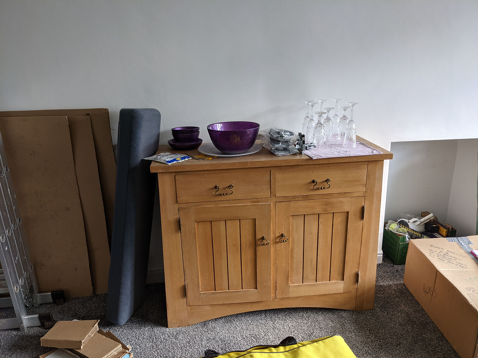 A before photo of the hole where the fireplace used to be, and the client's sideboard.