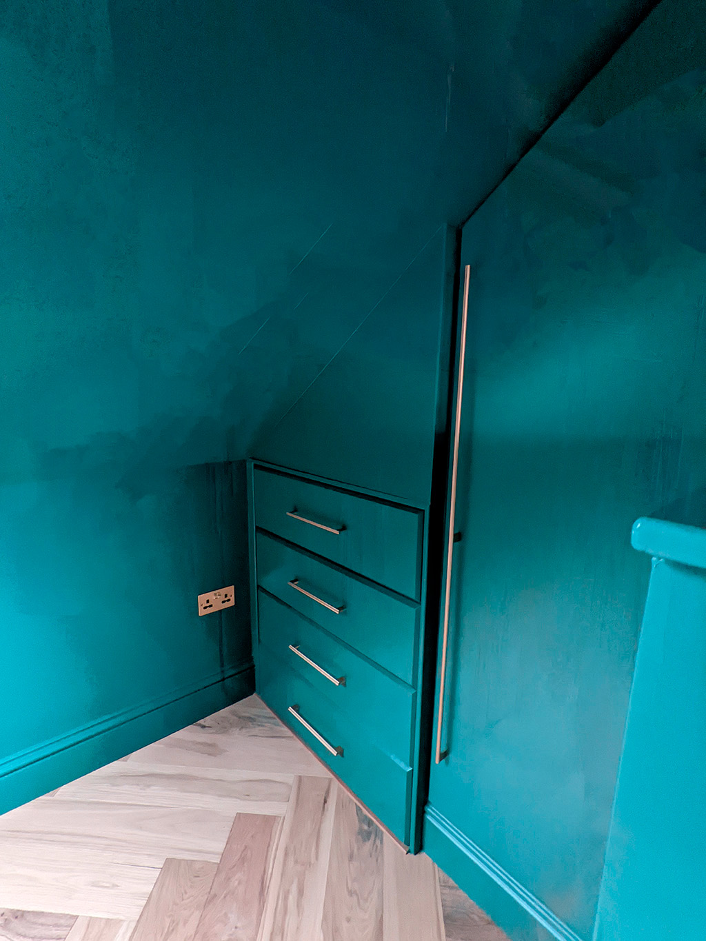 A photo of the painted drawers and tall cupboard in the bedroom.