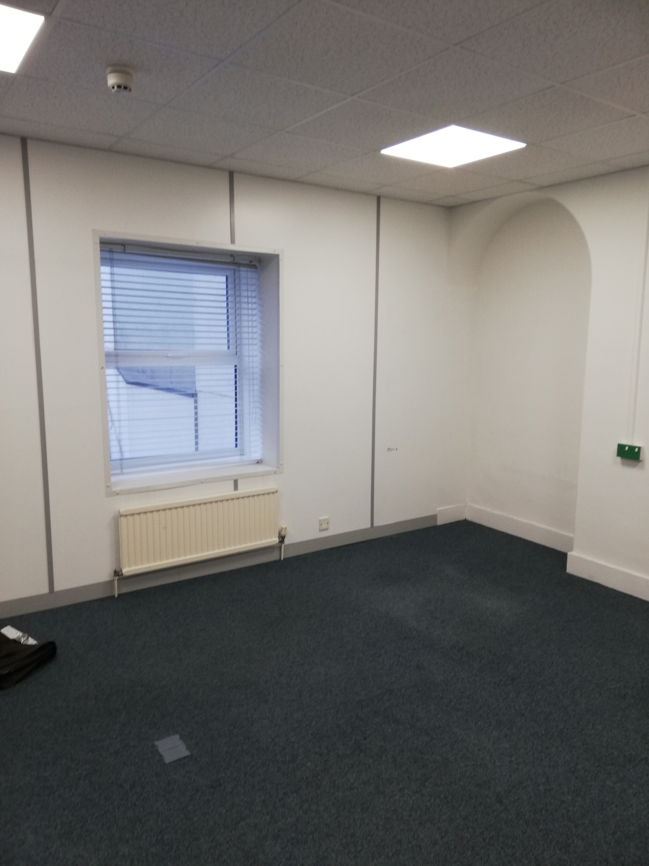 A photo of the office before it was decorated showing the windows and one of the alcoves.