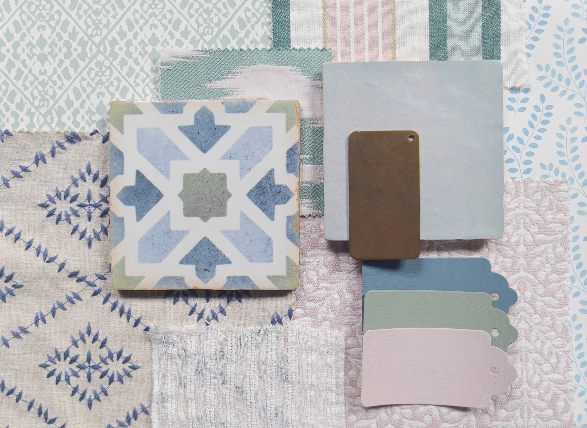 A photo of some fabric, wallpaper and tile samples arranged together.