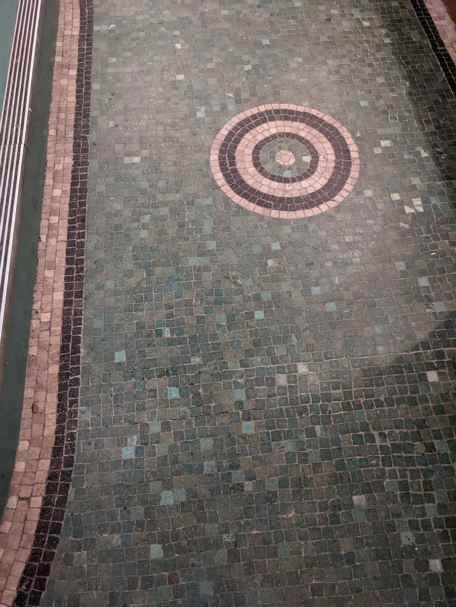 A photo of the tiled green floor of the basement area