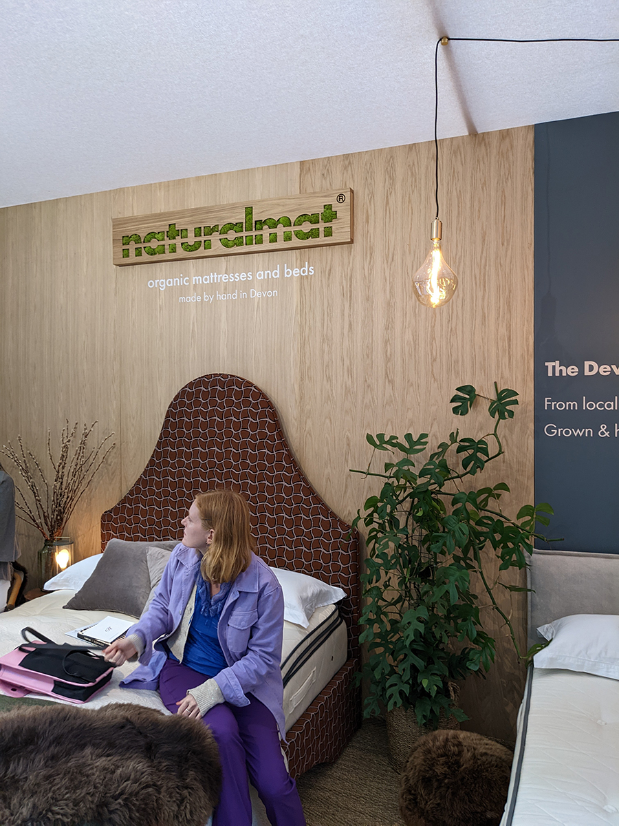 A photo showing a shaped upholstered headboard on the Naturalmat stand.