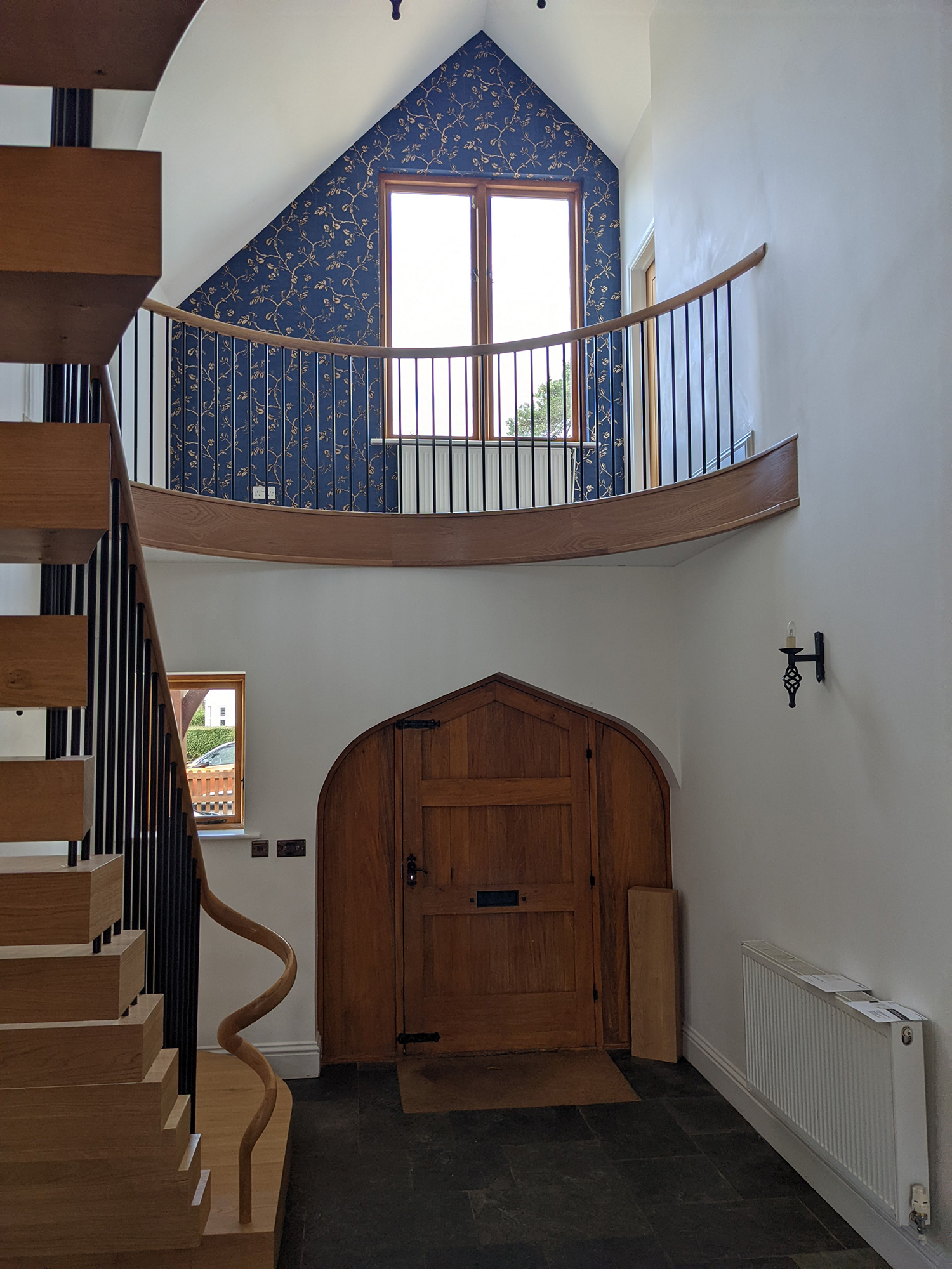 A photo of the hallway showing the oak staircase and white walls.