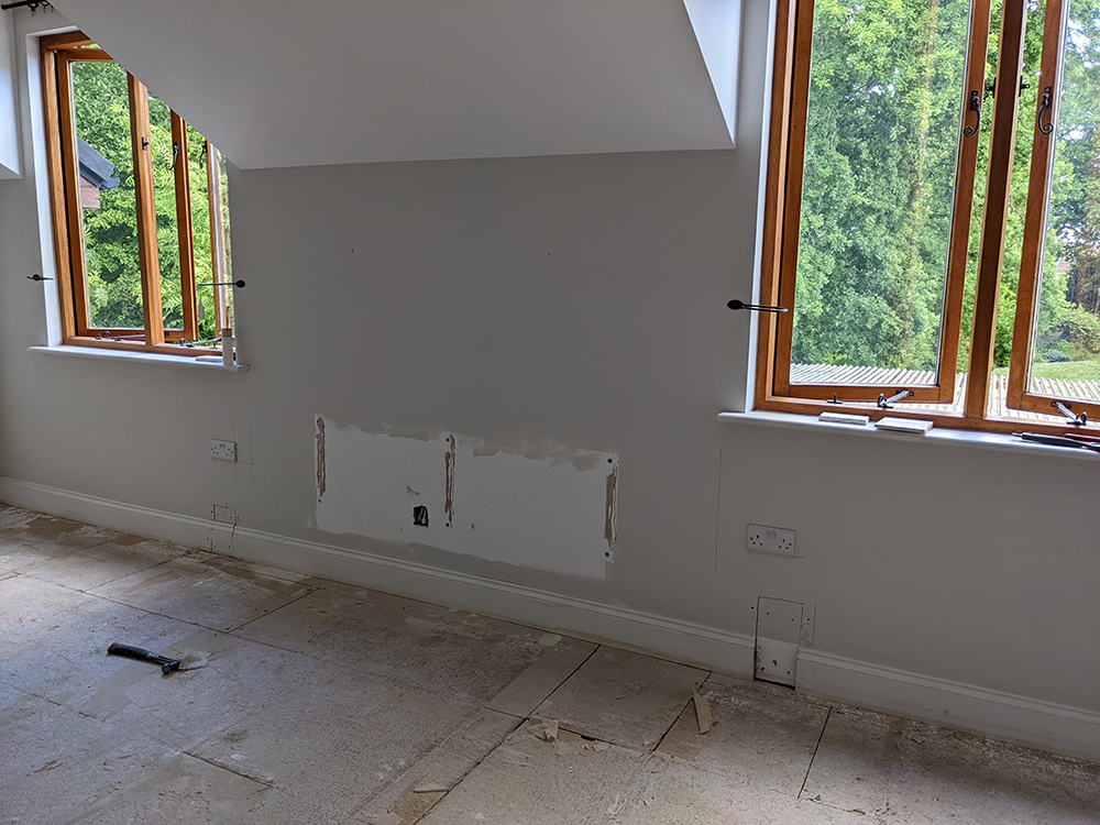 A photo of the main bedroom where the skirting board has been cut to add the plug sockets.