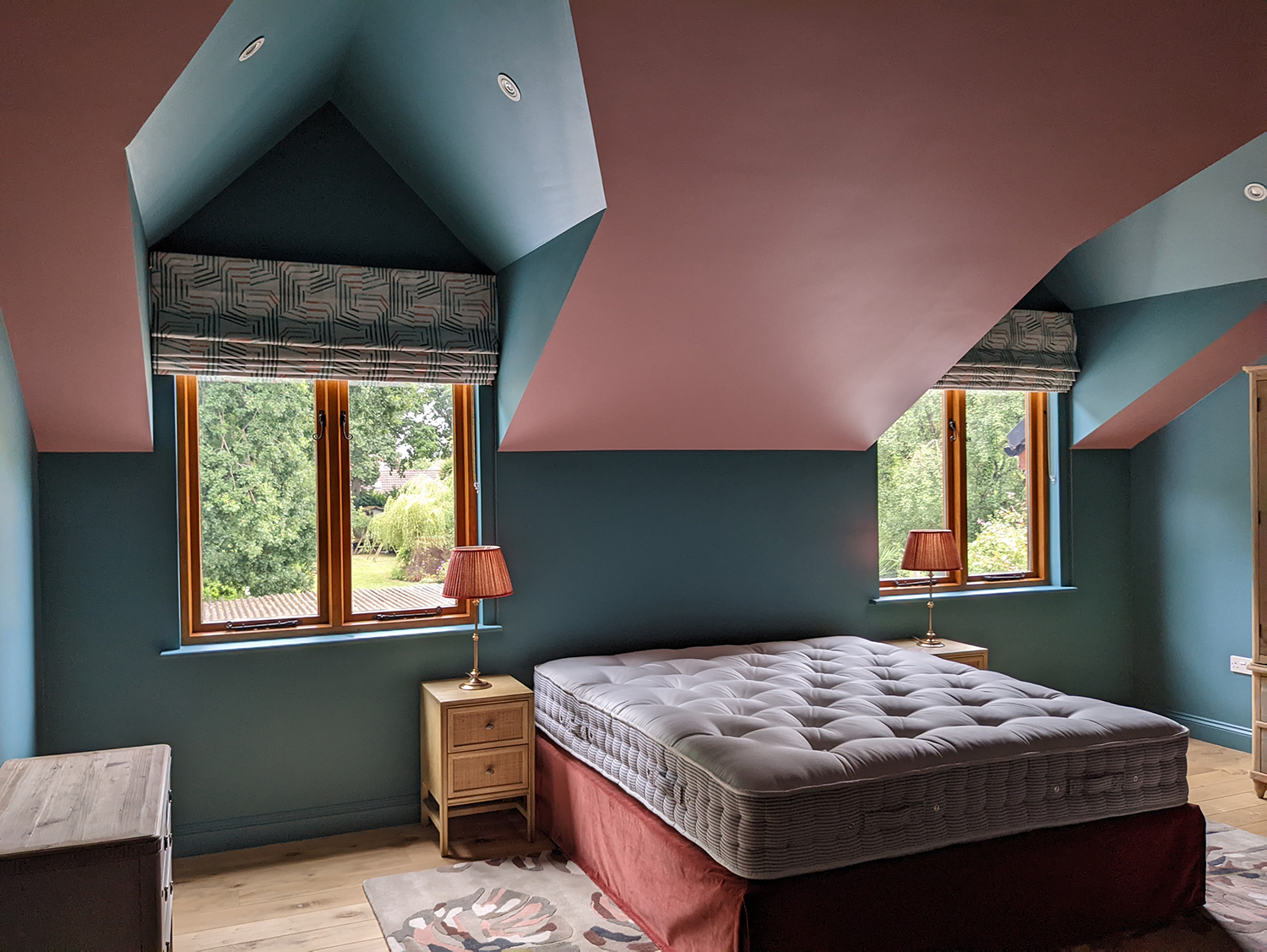 A photo of the partially finished main bedroom with blush pink walls and a teal ceiling.
