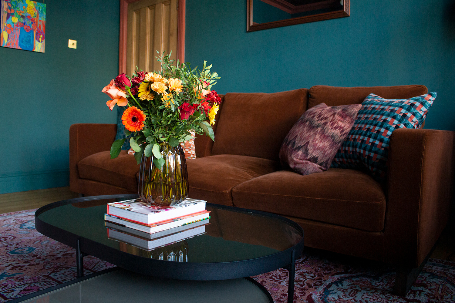 A photo of the brown velvet sofa with colourful cushions and the galls coffee tables in my finished living room.