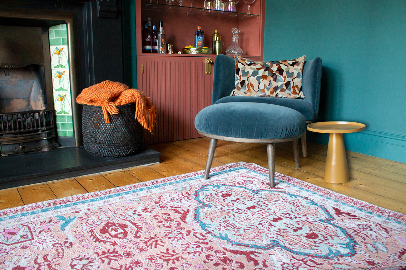 A photo showing the patterned rug with the blue chair and footstool.