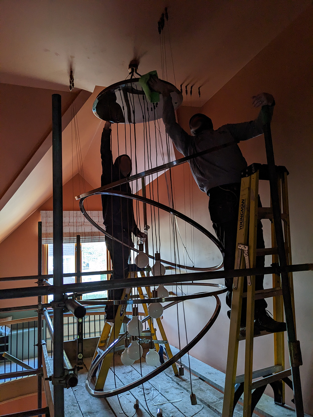 A photo of the electricians cleaning the chandelier