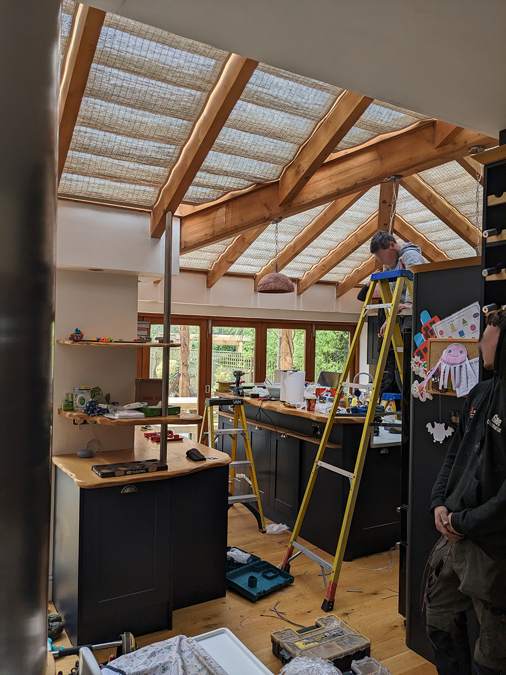 A photo showing the electricians installing the new pendant lights in the kitchen.