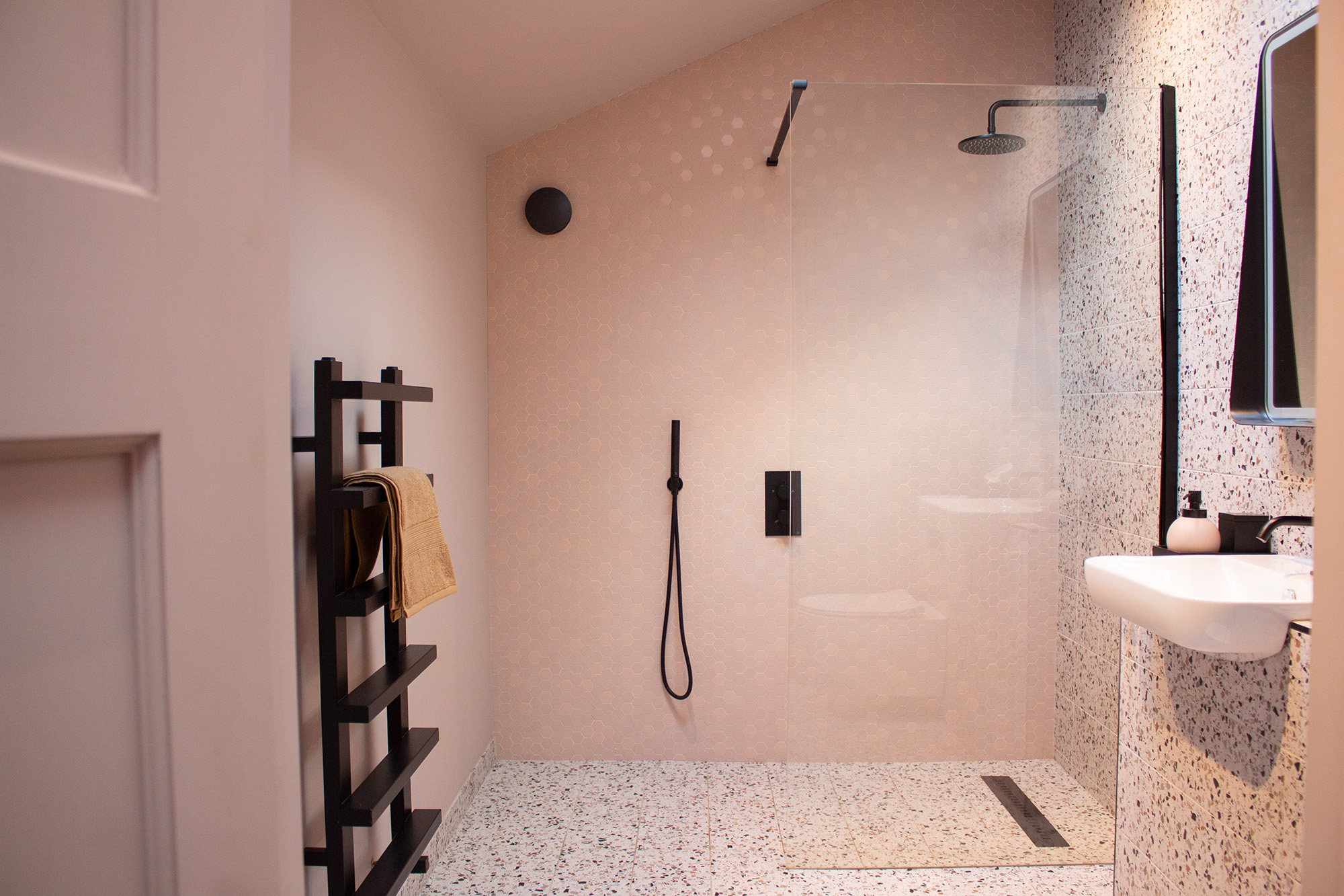 A photo of a pink bathroom with lots of space around the fuxtures.