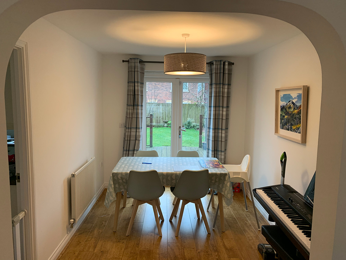 A photo showing a dining room with not enough space to pull out the chairs 