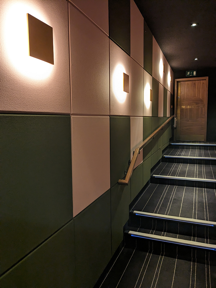 A wall covered in square sound absorbent panels with lighting 