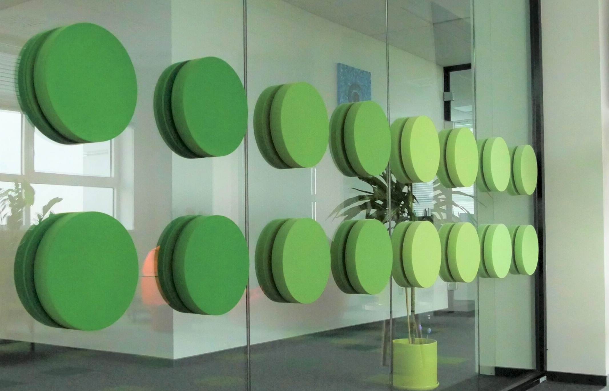 A glass wall covered in circular sound absorbent panels 