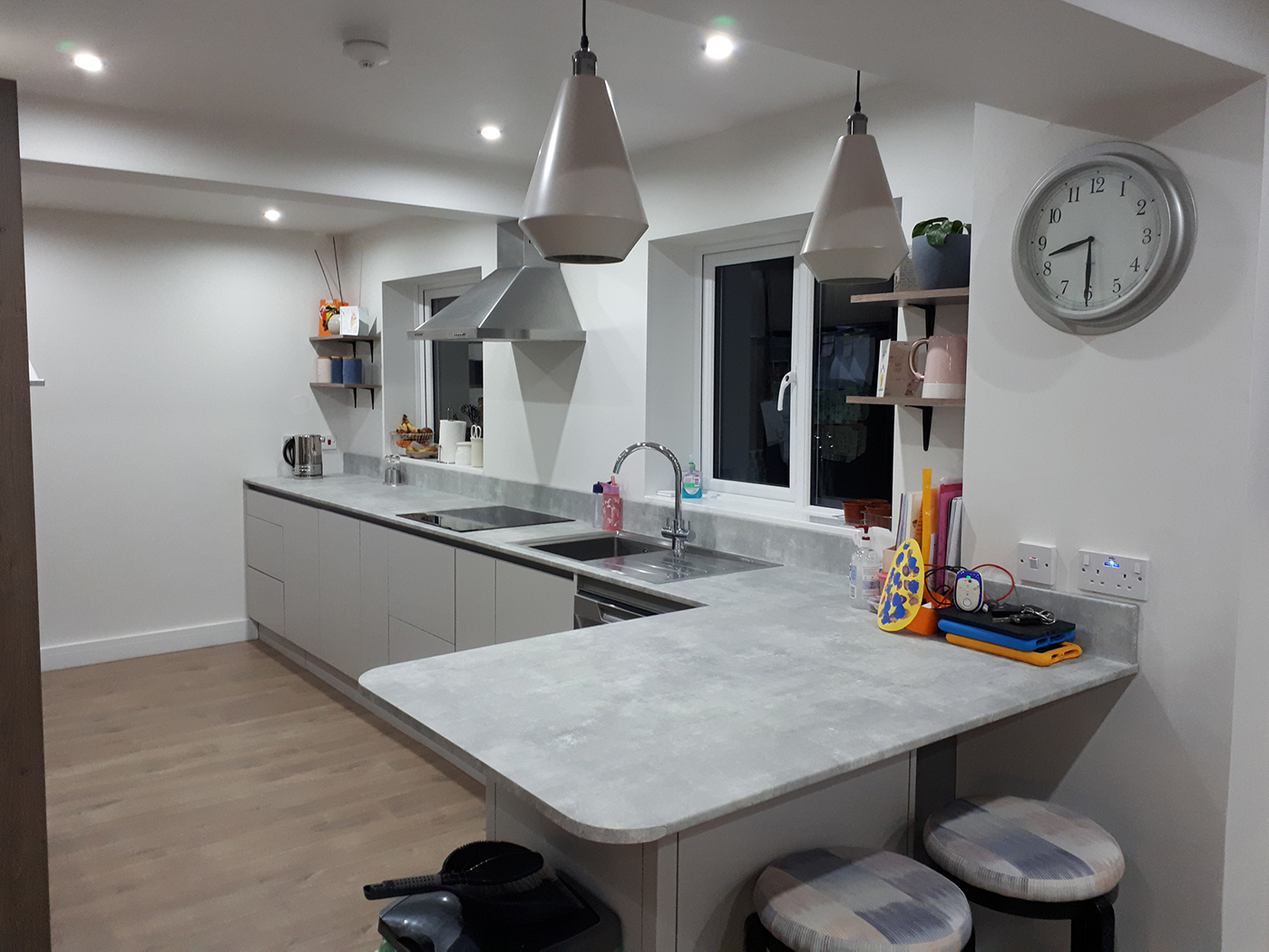 A kitchen with white walls, white cupboards and grey countertops