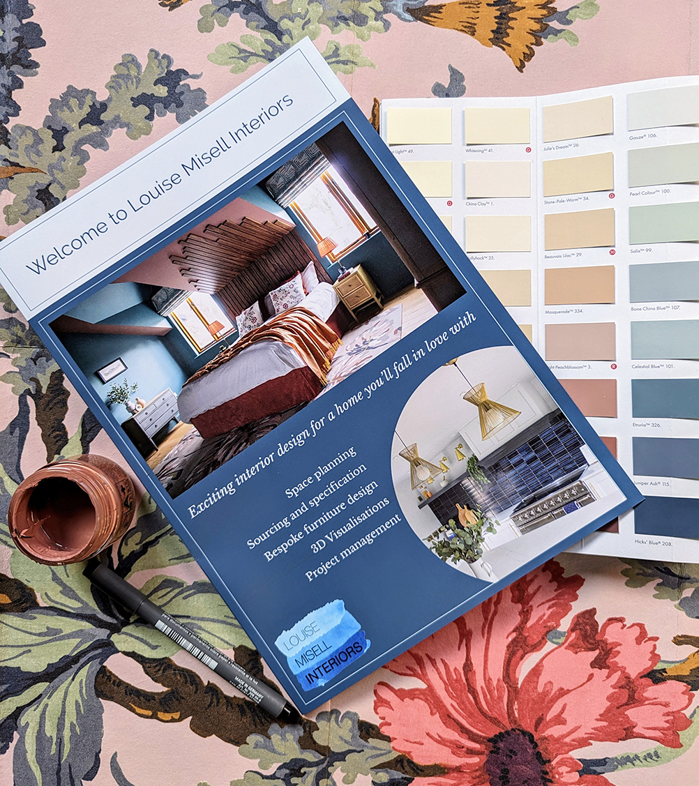 A image that shows a welcome pack folder layered on top of wallpaper and paint samples 