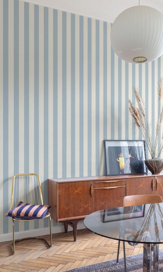 An image from Pinterest showing a pale blue striped wallpaper in a living room