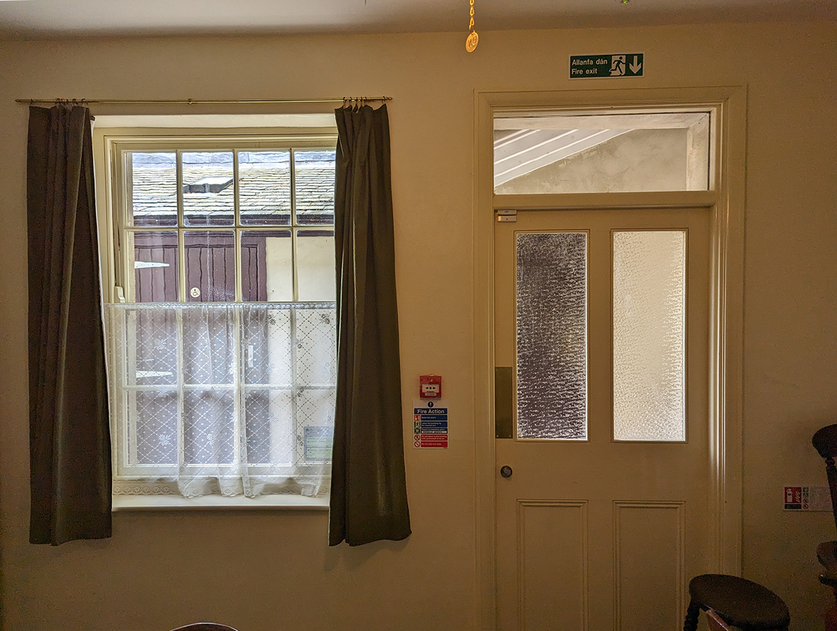  a photo showing a window dressed with curtains and a net curtain