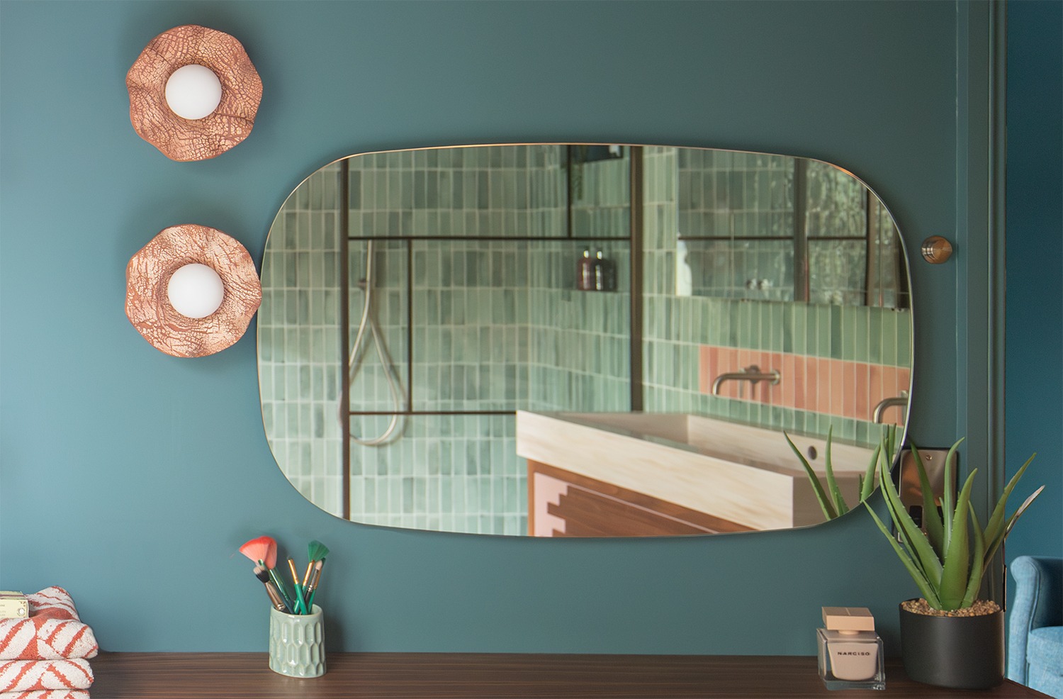 A close up view of the mirror above the dressing table, showing the shower control.