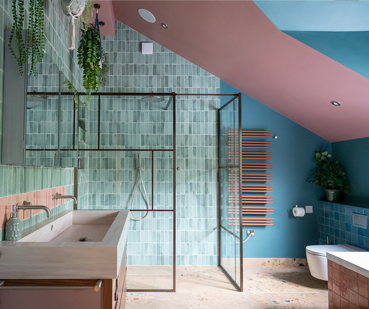 A photo of the finished room showing the shower area with bronze screens and green tiles.