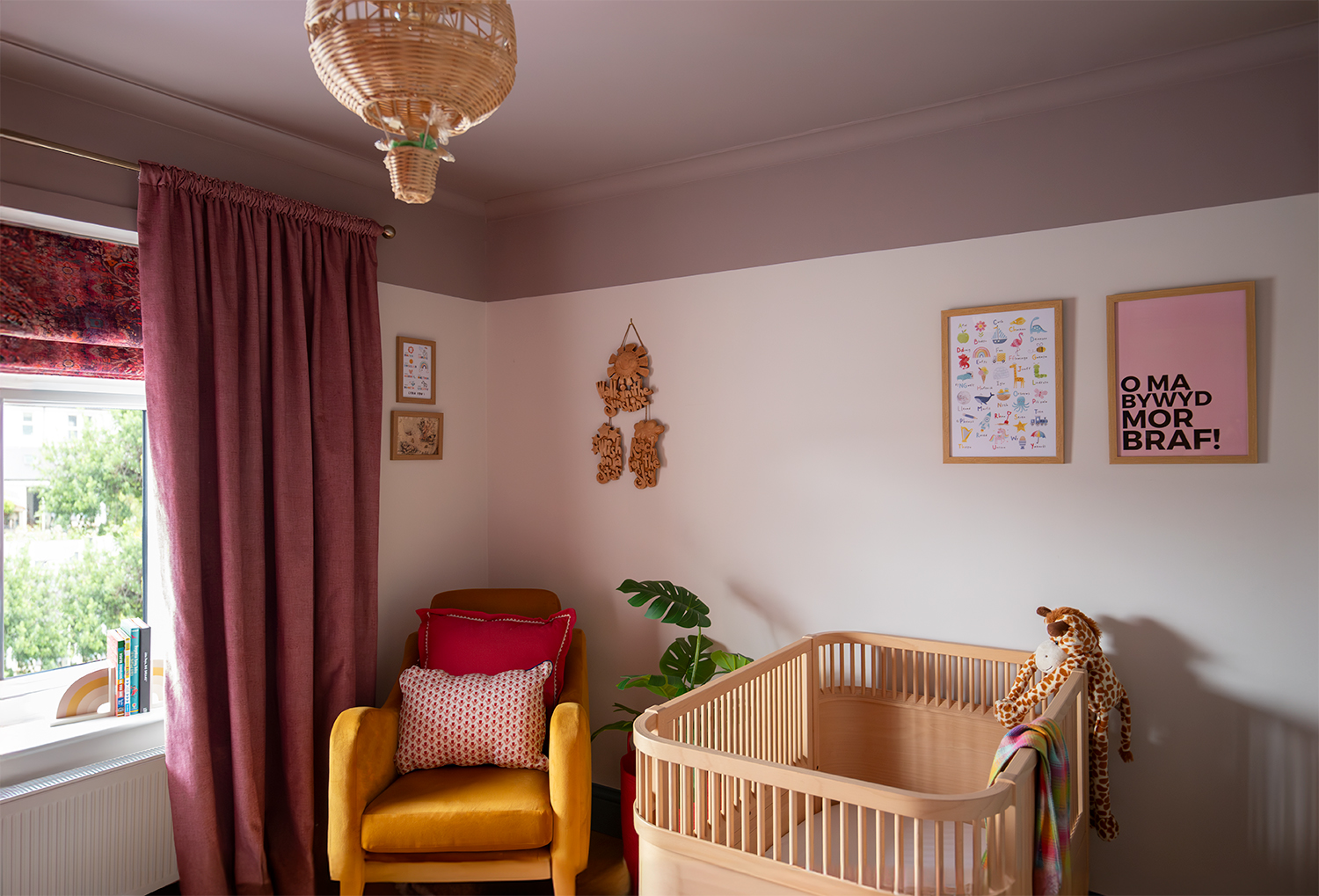 A mustard armchair with pink cushions 