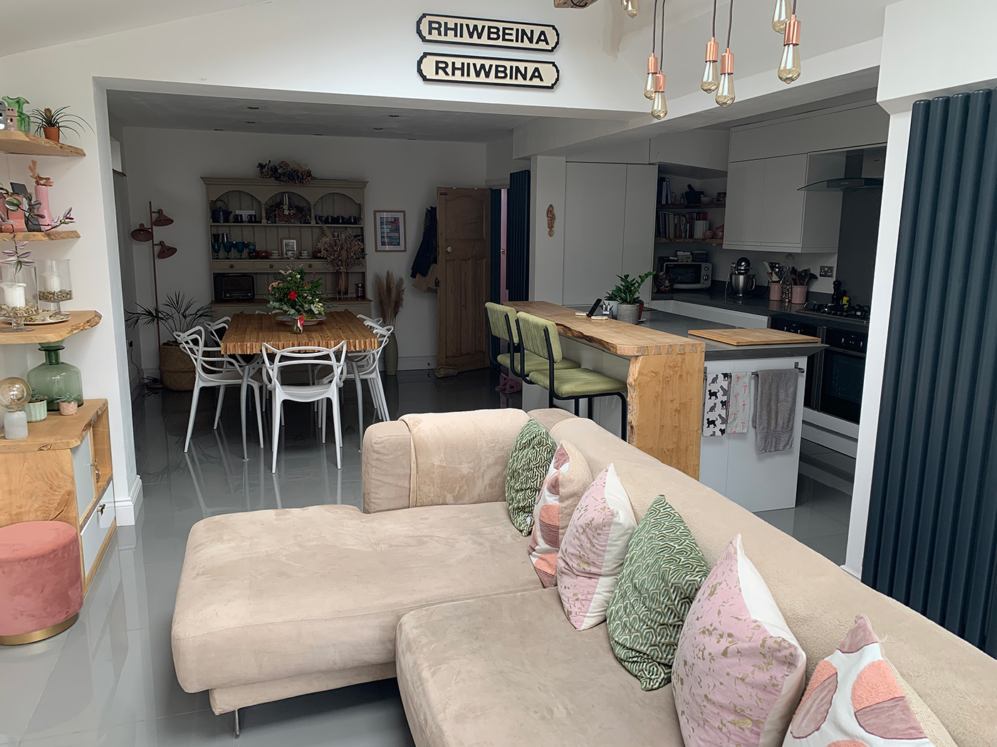 A living room with white walls and cream corner sofa 