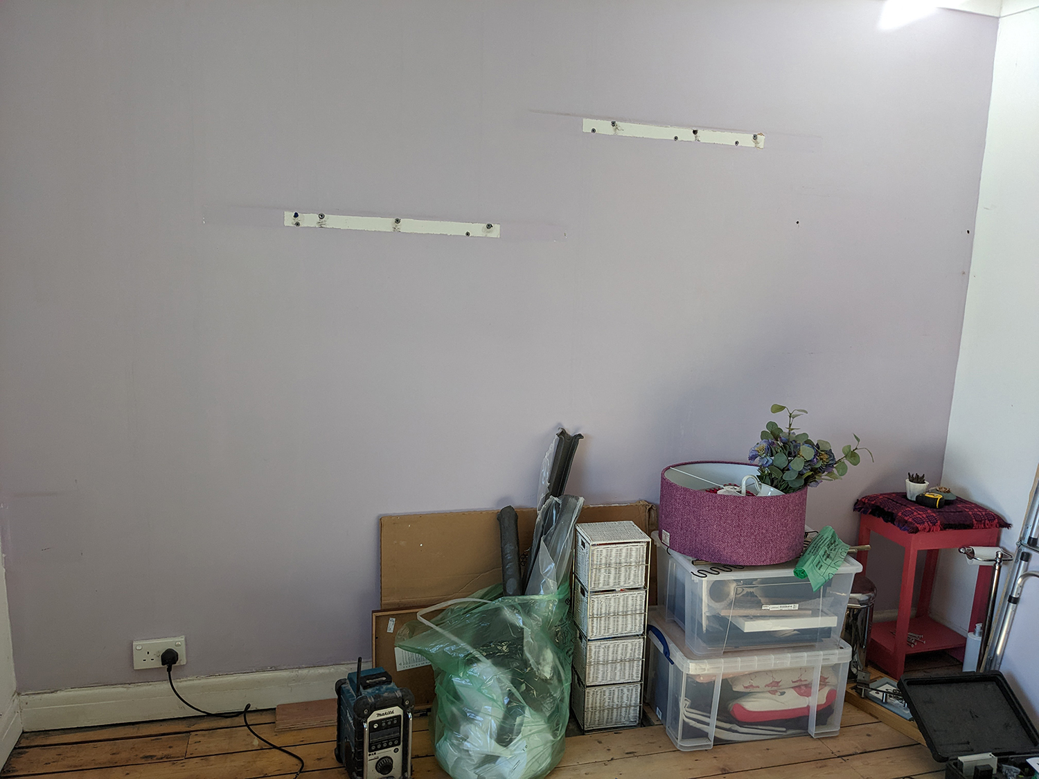 An empty room with Lilac wall and wooden floor 