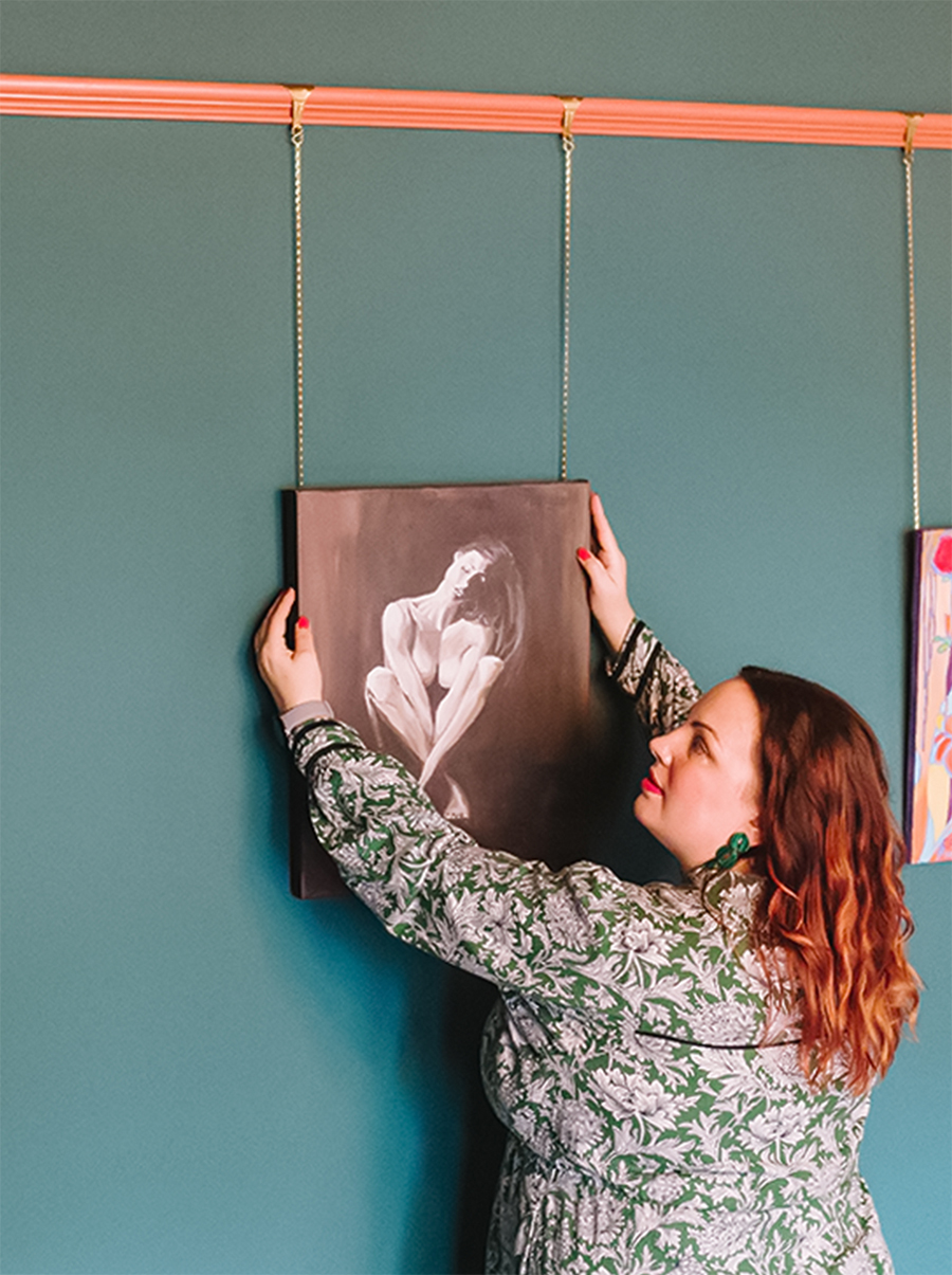 Louise hanging artwork on the wall