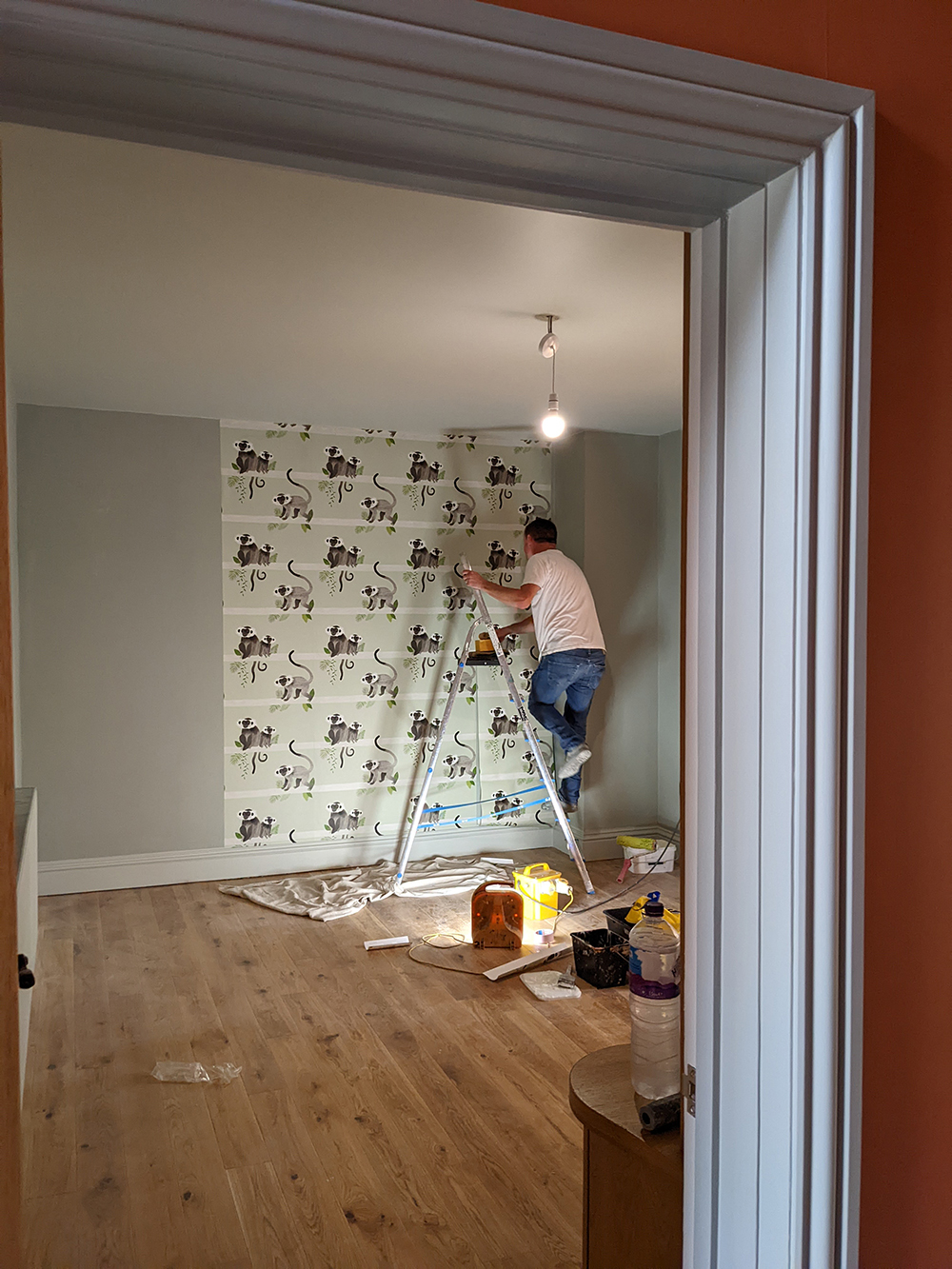 a decorator putting up wallpaper 