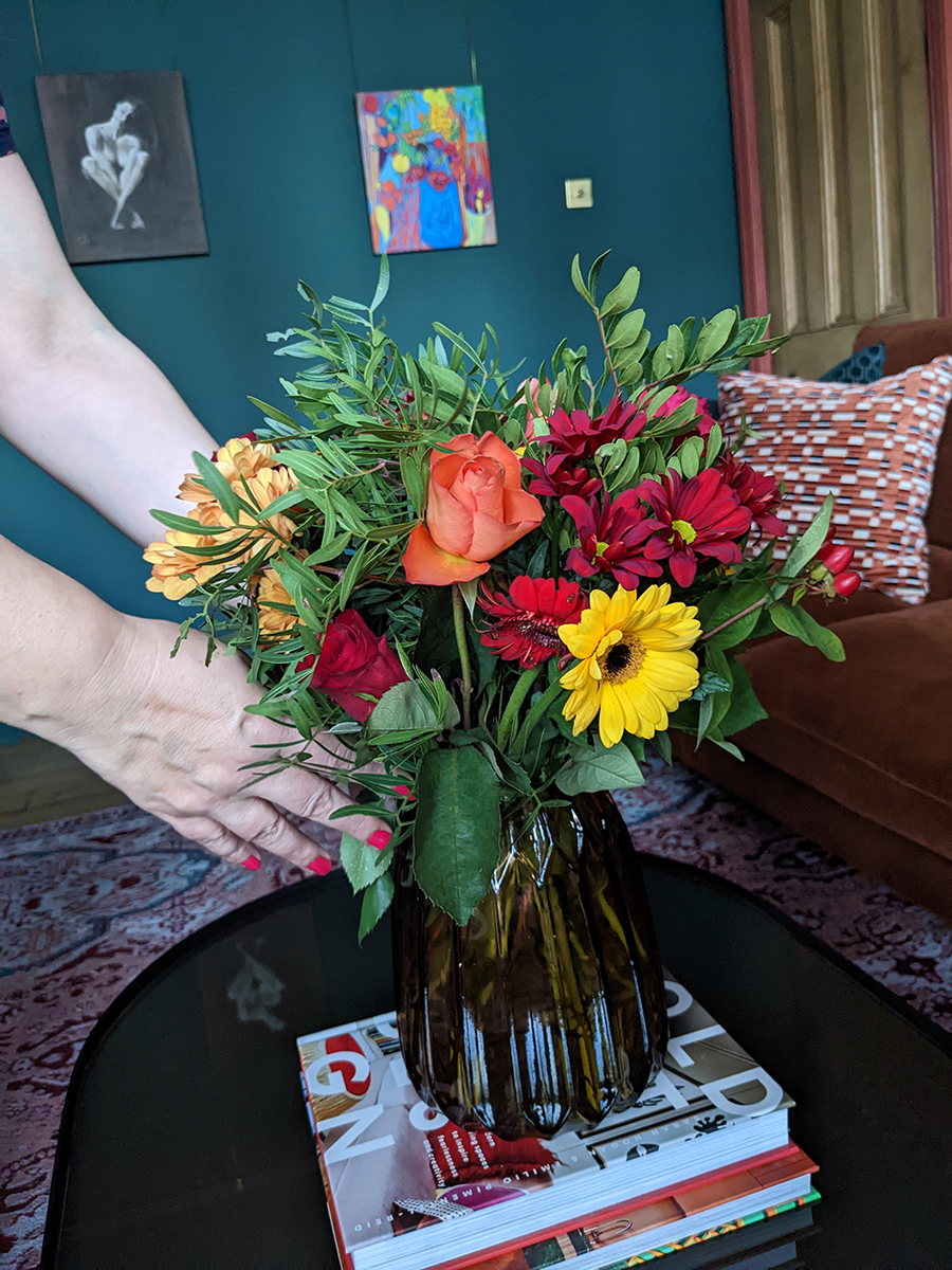 Louise adding fresh flowers to a table display