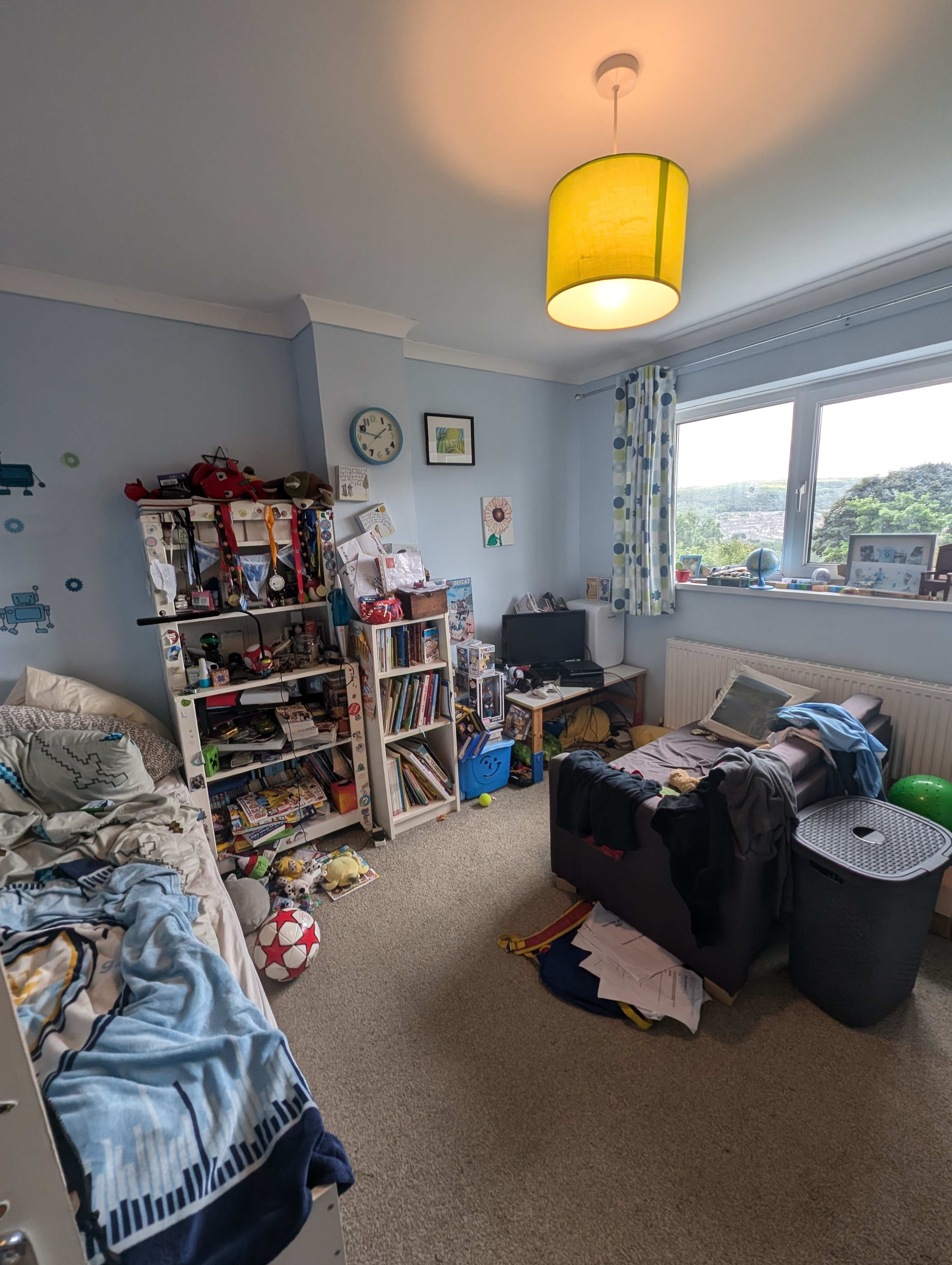 A photo of a boys room with small sofa and TV set up for playing console games