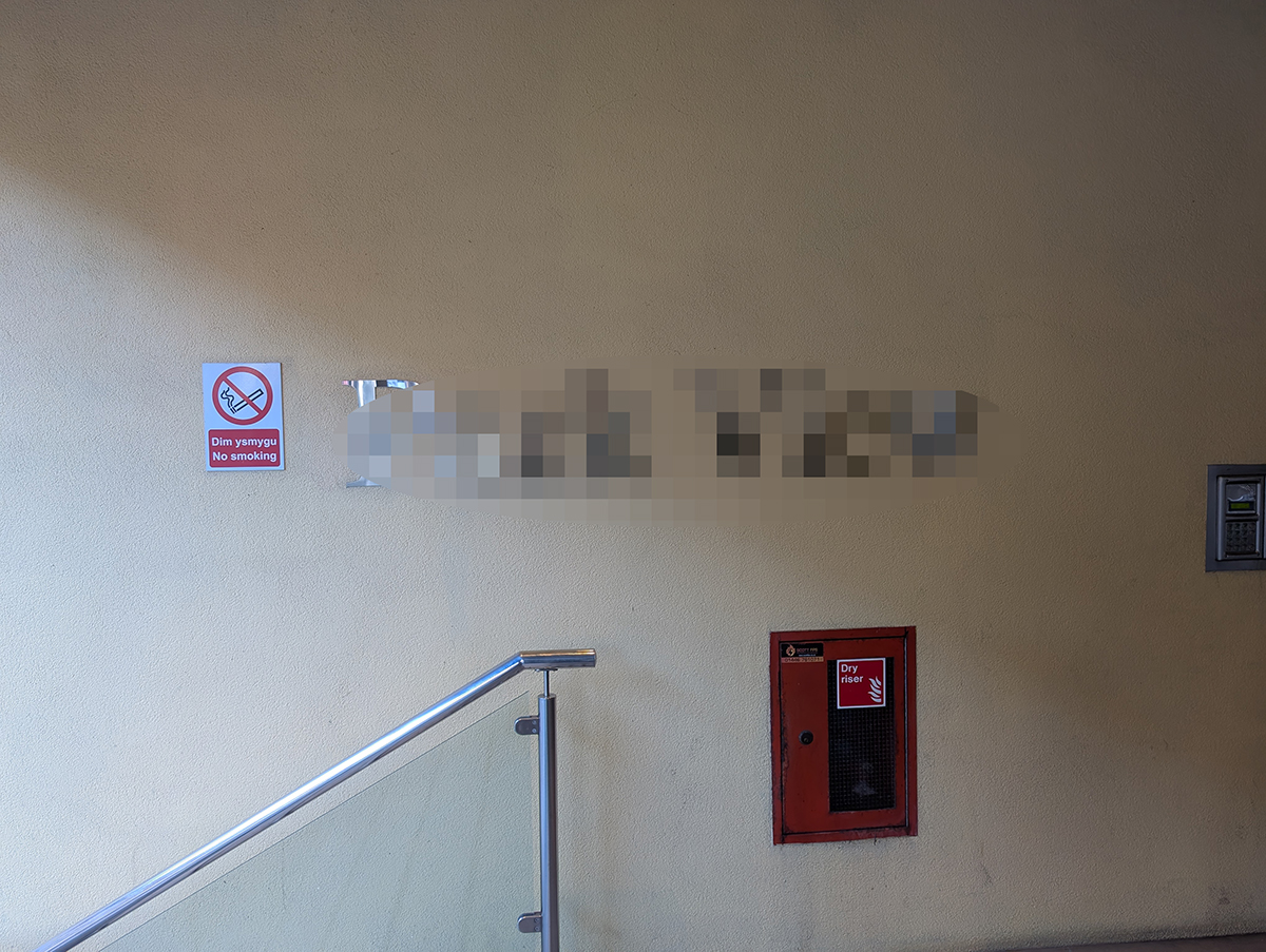 A before photo showing the name of the apartments in chrome.