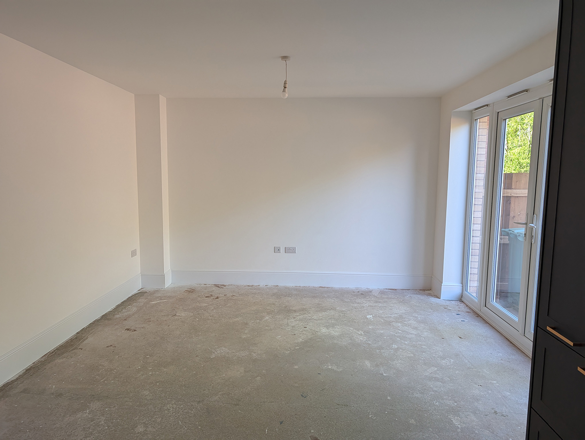 A kitchen snug with bare white walls and no flooring