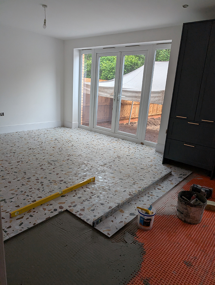 A kitchen with a colourful terrazo floor 