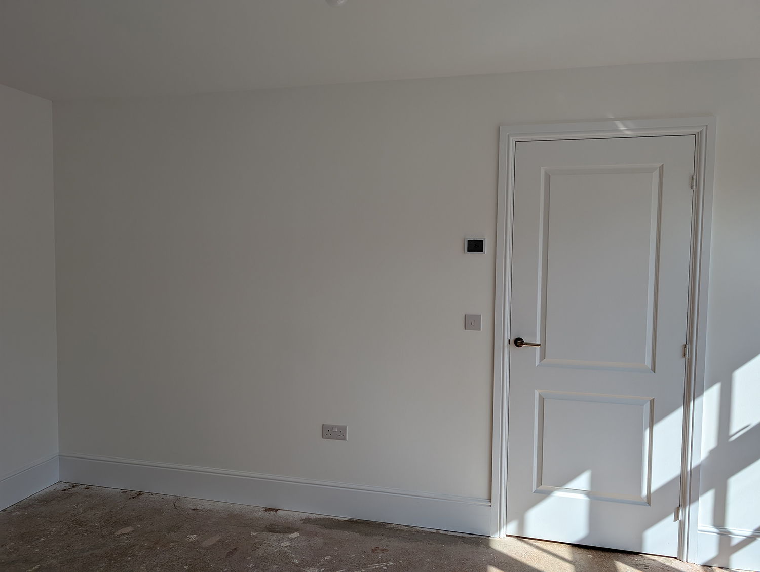 A living room with bare white walls and no flooring 
