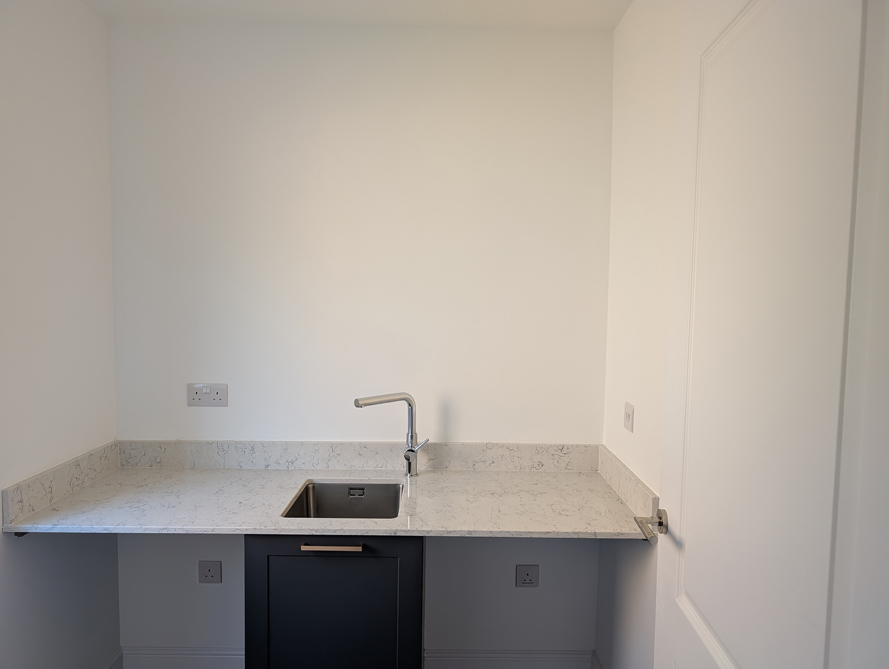 A utility room with all white walls and ceiling 