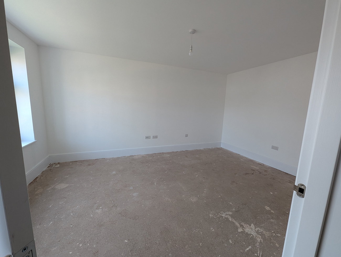 A living room with bare white walls and no flooring