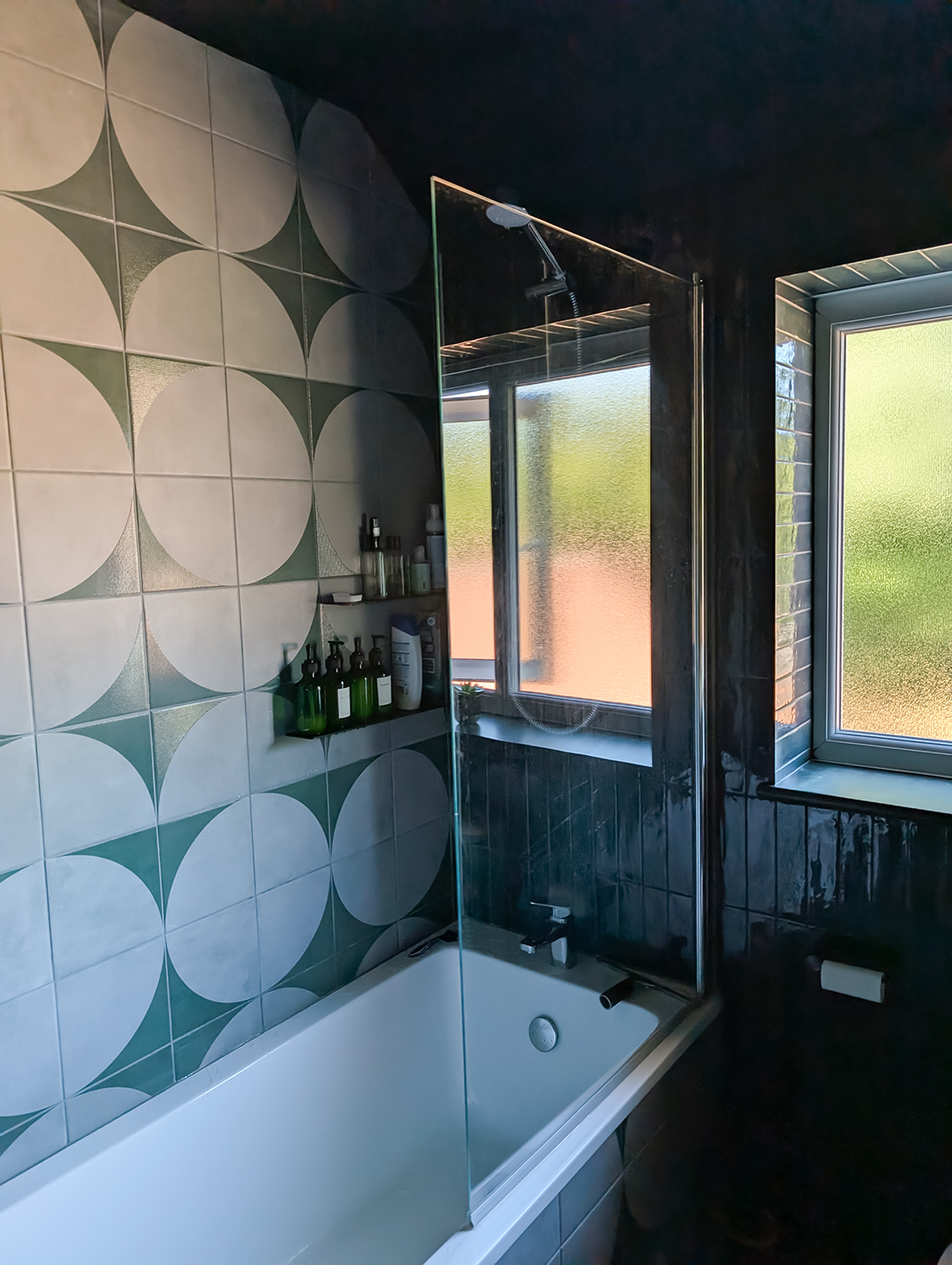 A new build bathroom with dark green wall tiles