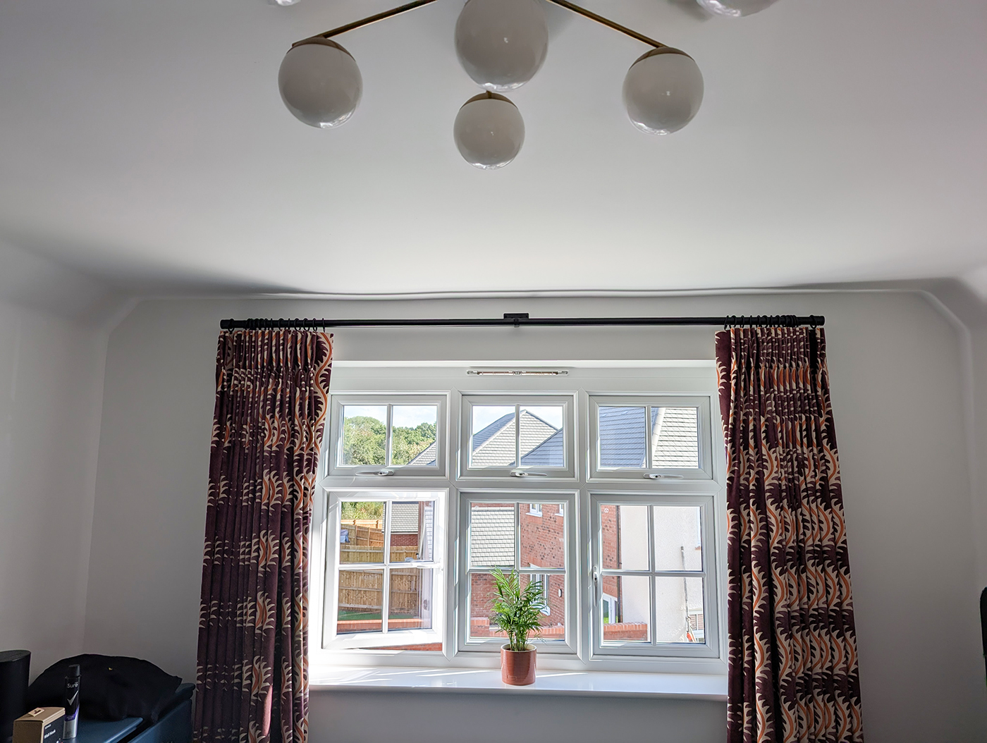 A new build bedroom with burgandy full length curtains