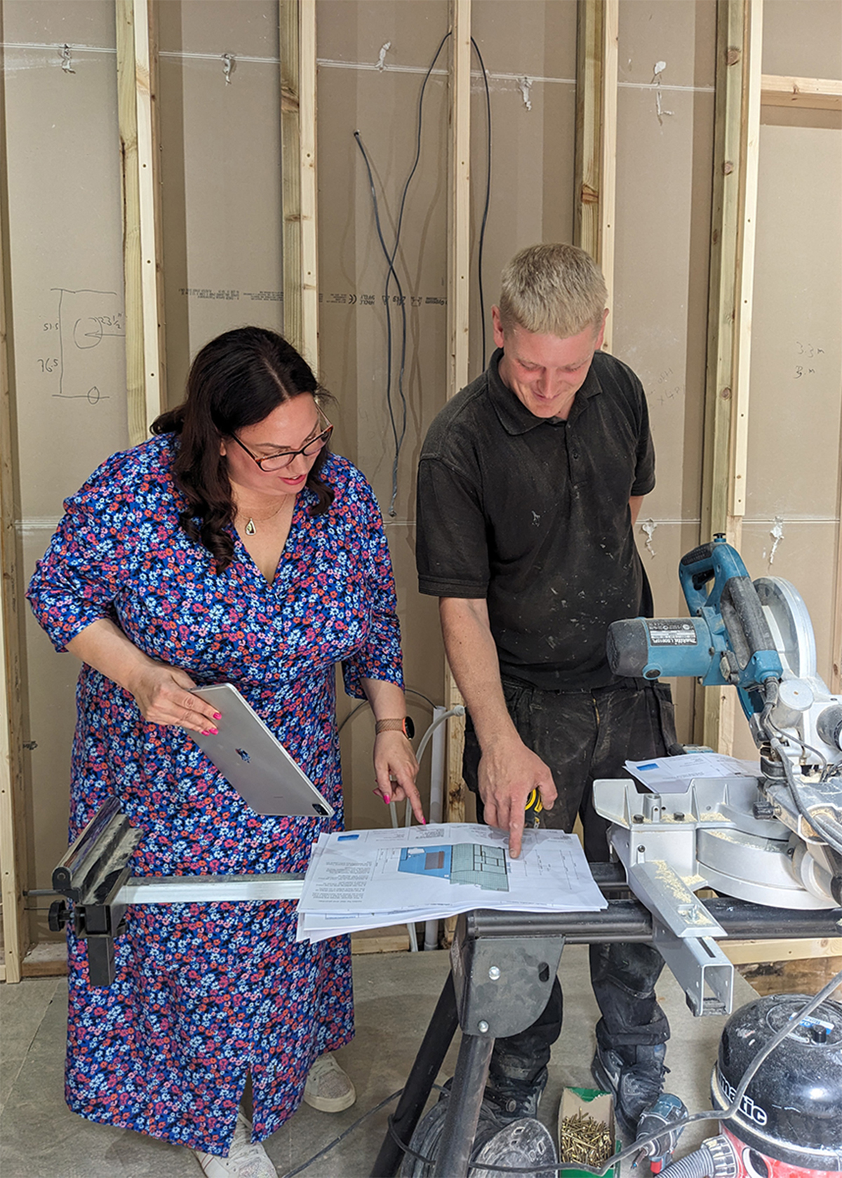 A photo of a designer and a builder looking at renovation plans 